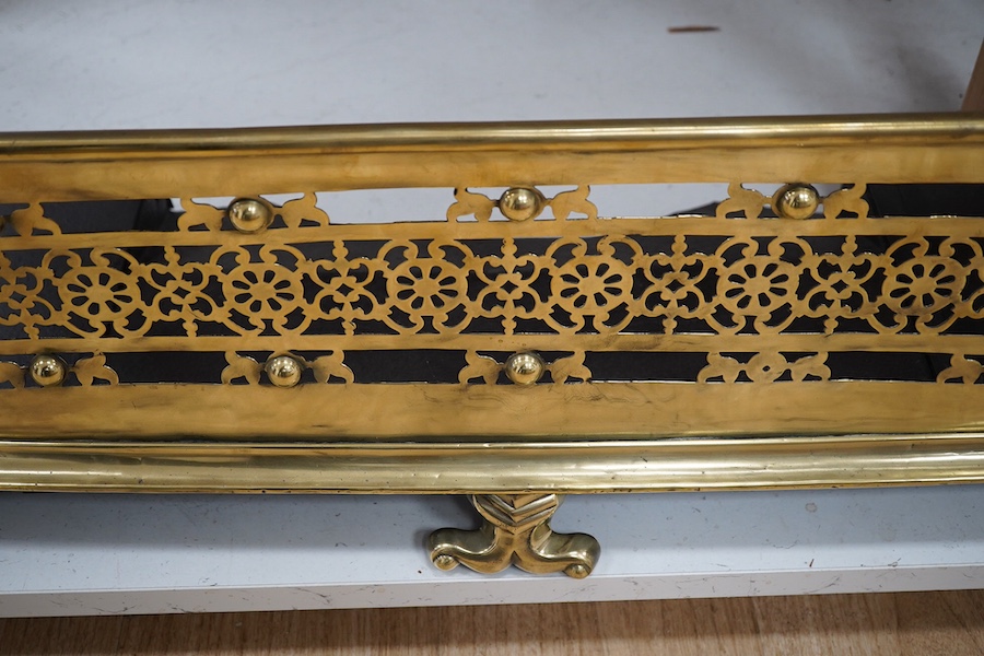 An early 19th century brass fender with pierced decoration, 91cm wide. Condition - fair to good